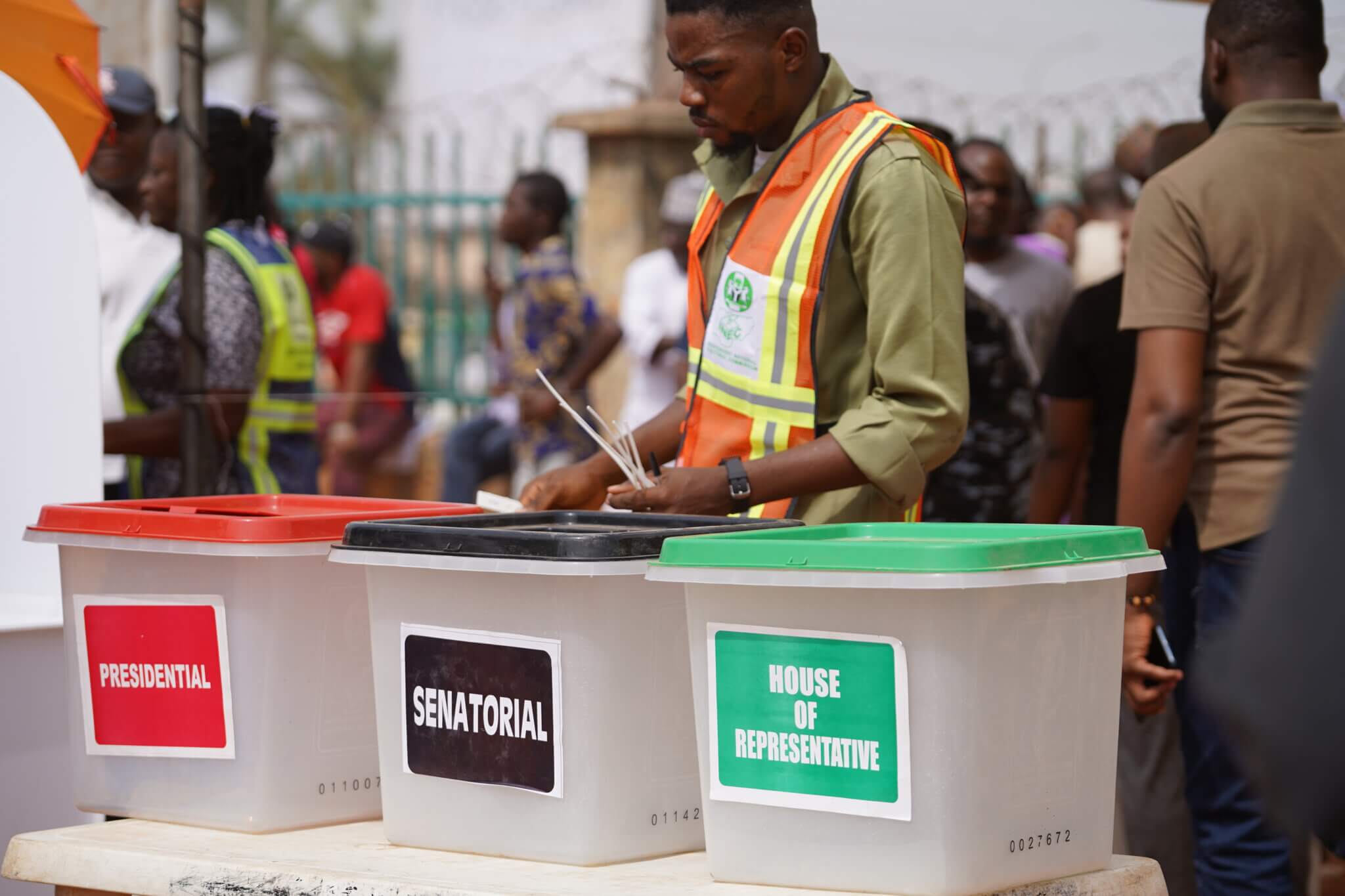 Mensch beim Wählen vor den Urnen in Nigeria